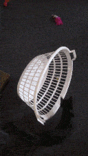 Pixie trying to get her toy from under the side of the basket, which is pushed over again.